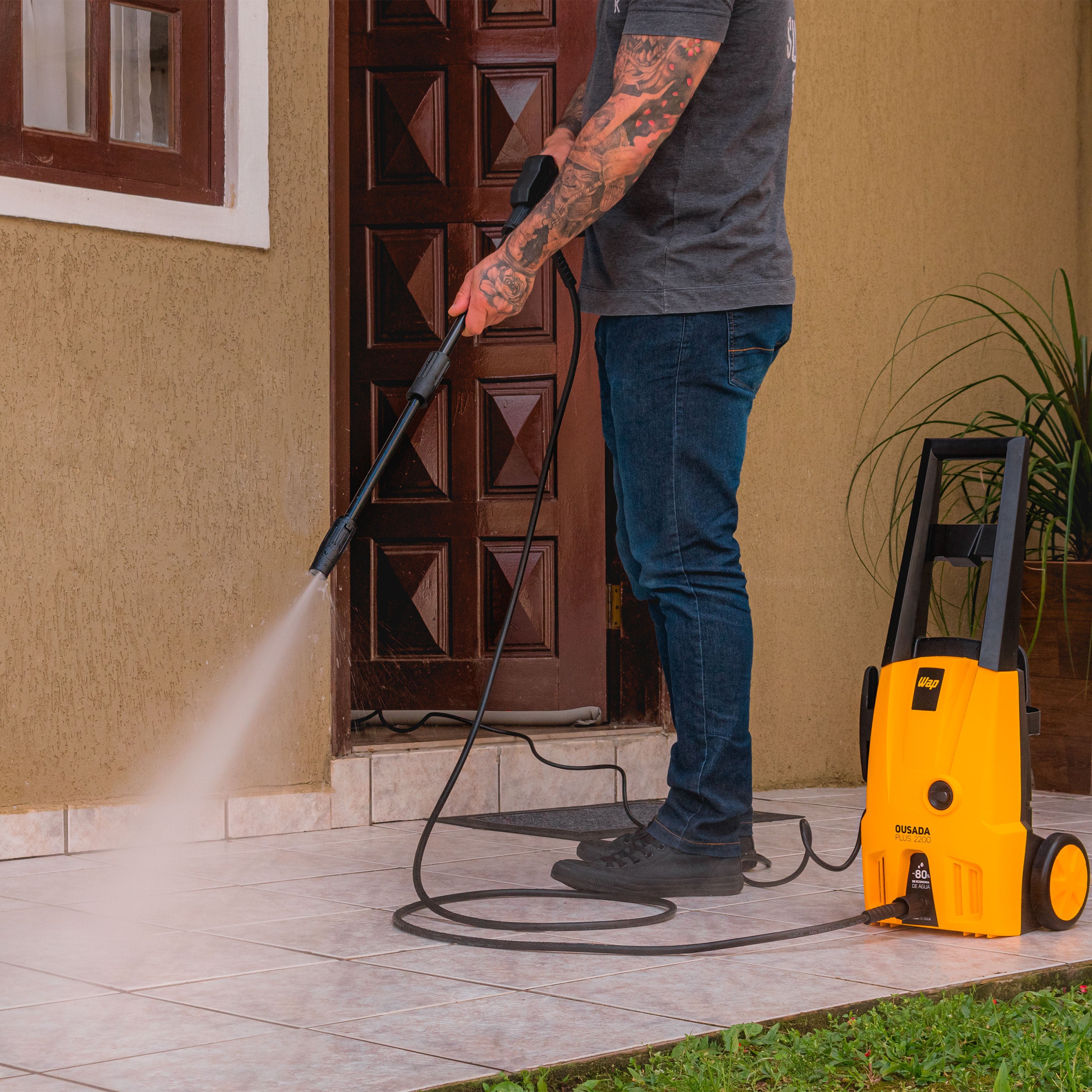 Homem lavando a entrada de casa com a WAP Ousada Plus 2200